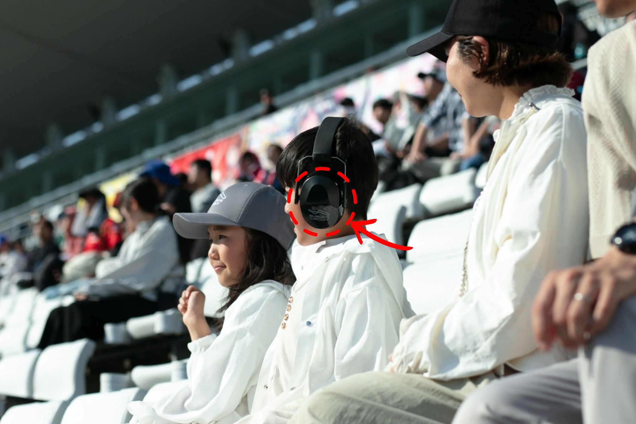 イヤーマフを着けてレースを観戦する子ども